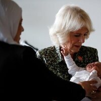 Camilla Parker sosteniendo a un bebé durante su visita oficial a Jordania