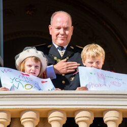 Alberto de Mónaco y Jacques y Gabriella de Mónaco con unas pancartas con un mensaje a Charlene de Mónaco en el Día Nacional de Mónaco 2021