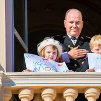 Alberto de Mónaco y Jacques y Gabriella de Mónaco con unas pancartas con un mensaje a Charlene de Mónaco en el Día Nacional de Mónaco 2021