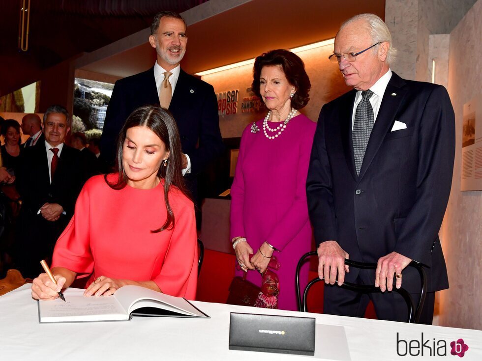 La Reina Letizia firmando en el Museo Nobel en presencia del Rey Felipe y los Reyes de Suecia