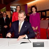 El Rey Felipe firmando en el Museo Nobel en presencia de la Reina Letizia y los Reyes de Suecia