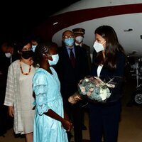 La Reina Letizia recibe un ramo de flores de manos de una niña a su llegada a Senegal