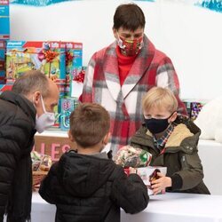 Jacques de Mónaco da regalos a un niño en presencia de Estefanía de Mónaco en la entrega de regalos navideños 2021