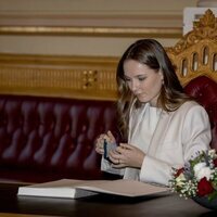 Ingrid Alexandra de Noruega firmando en el libro de visitas del Parlamento de Noruega en su visita por su 18 cumpleaños