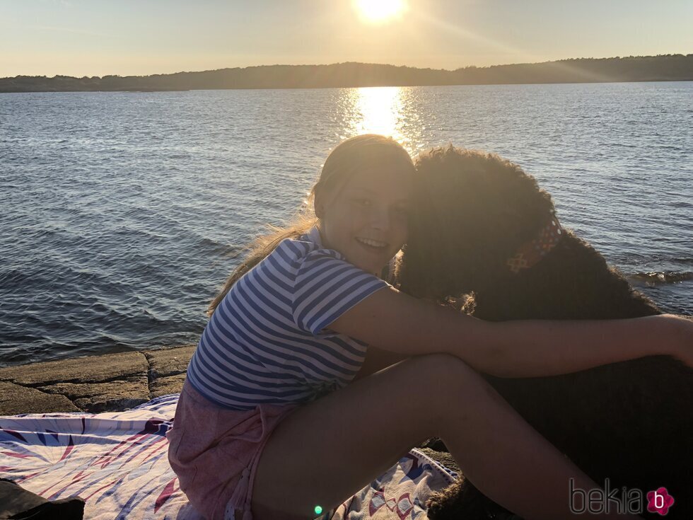 Ingrid Alexandra de Noruega posando con su perro junto a un fiordo