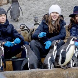 Mary de Dinamarca y sus hijos Vicente y Josefina de Dinamarca con unos pingüinos en la inauguración del Mary's Australian Garden en el zoo de Copenhague