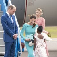 Una niña hace la reverencia al Príncipe Guillermo y Kate Middleton a su llegada a Las Bahamas