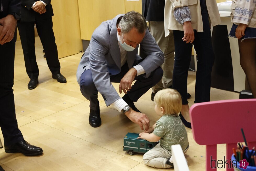 El Rey Felipe con un bebé en su visita a un centro de refugiados ucranianos