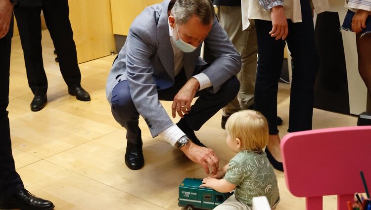 El Rey Felipe con un bebé en su visita a un centro de refugiados ucranianos