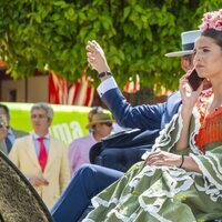 Tana Rivera hablando por el móvil en un coche de caballos en la Feria de Abril 2022