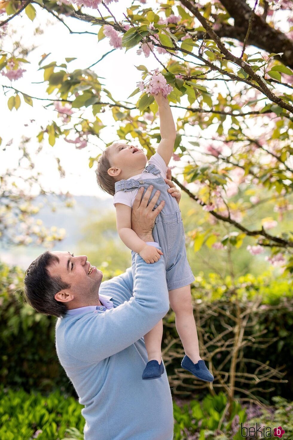 Guillermo de Luxemburgo sube en brazos a su hijo Charles de Luxemburgo para que toque una flor en el 2 cumpleaños de Charles de Luxemburgo