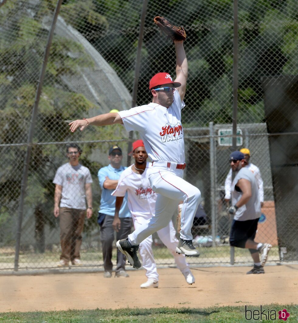 Nick Jonas jugando al beisbol ante la atenta mirada de Joe Jonas