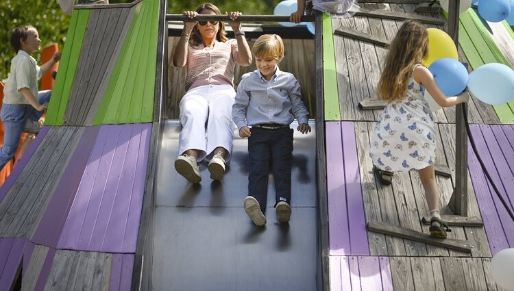 Magdalena de Suecia y Nicolas de Suecia tirándose por un tobogán en la inauguración del Discovery Park en Skuleberget