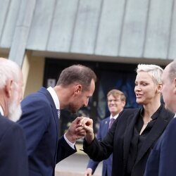 Haakon de Noruega saluda a Charlene de Mónaco en presencia de Alberto de Mónaco en la inauguración de una exposición en Oslo