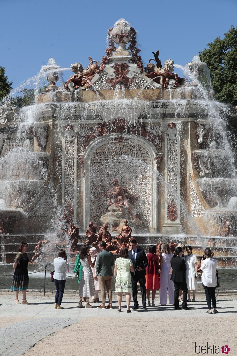 La Reina Letizia y Begoña Gómez con los y las acompañantes ante La Fuente de los Baños de Diana en su visita al Palacio de la Granja