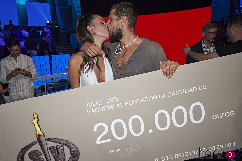 Alejandro Nieto y Tania Medina besándose junto al cheque de ganador en la final de 'Supervivientes 2022'