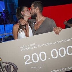 Alejandro Nieto y Tania Medina besándose junto al cheque de ganador en la final de 'Supervivientes 2022'