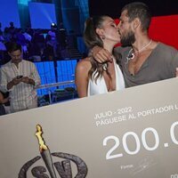 Alejandro Nieto y Tania Medina besándose junto al cheque de ganador en la final de 'Supervivientes 2022'