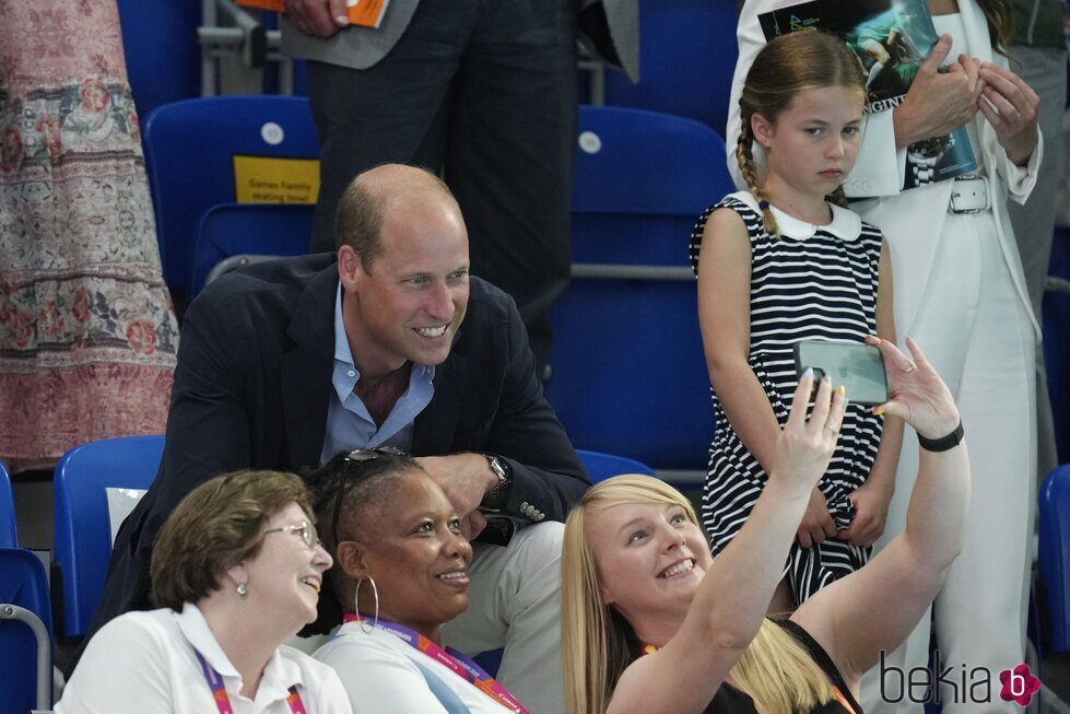 El Príncipe Guillermo se hace un selfie ante la mirada de la Princesa Charlotte en una competición de natación en los Juegos de la Commonwealth 2022