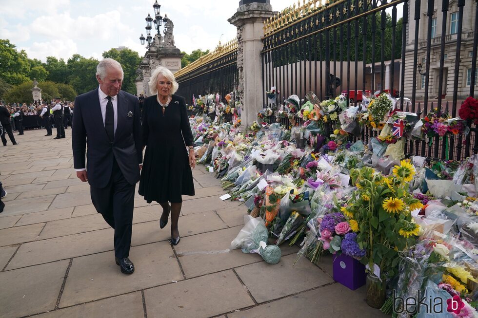 El Rey Carlos y la Reina Camilla miran las flores a las puertas del Buckingham Palace