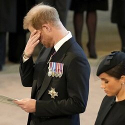 El Príncipe Harry con gesto apenado y Meghan Markle en la misa en Westminster por la Reina Isabel II