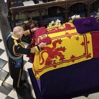 El Rey Carlos III coloca una bandera sobre el féretro de la Reina Isabel II