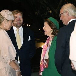 Carlos Gustavo y Silvia de Suecia y Guillermo Alejandro y Máxima de Holanda hablando en el Museo Vasa de Estocolmo