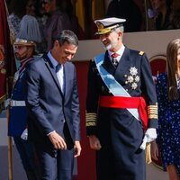 Pedro Sánchez y Felipe VI bromeando en el desfile militar por la Fiesta Nacional 2022