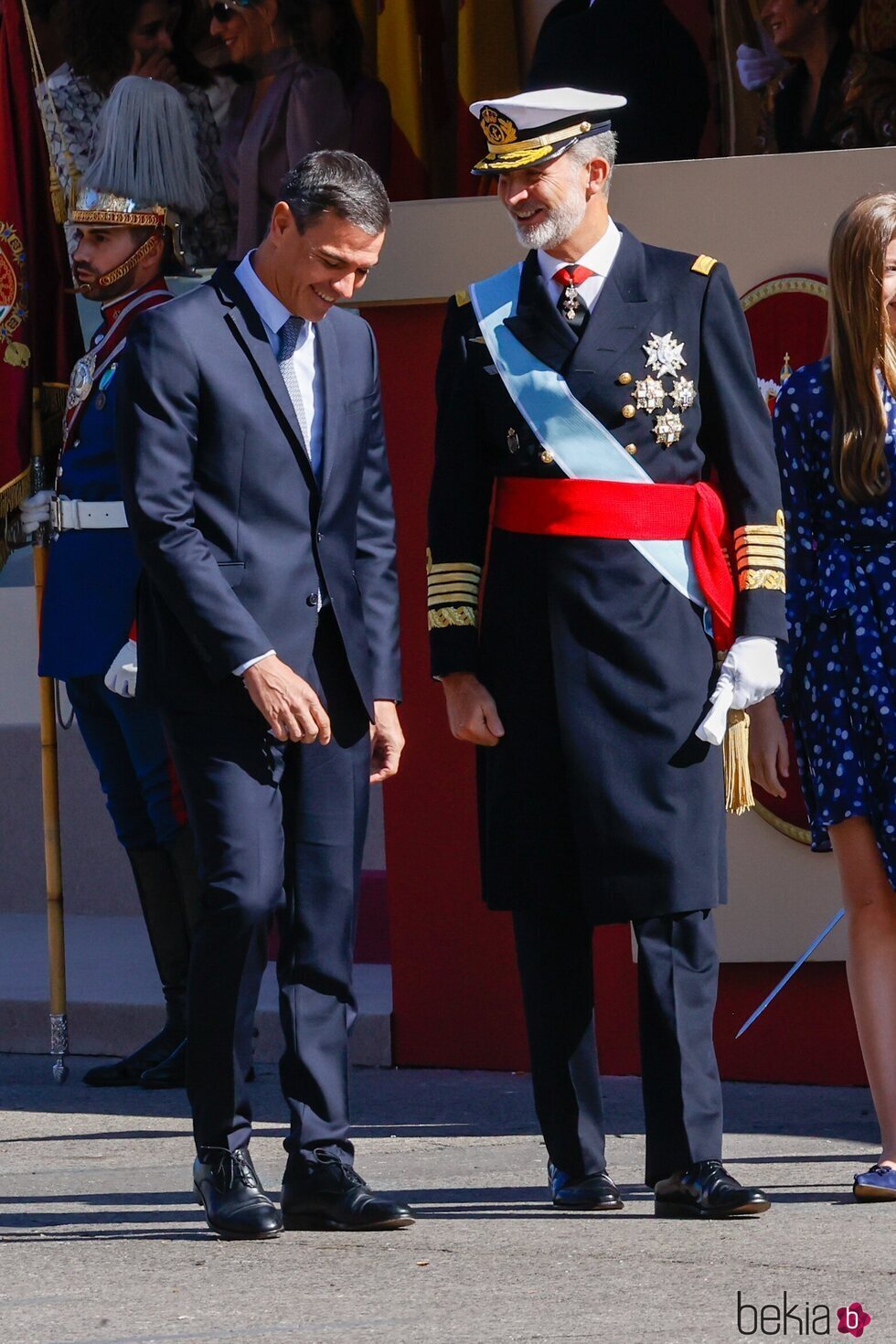 Pedro Sánchez y Felipe VI bromeando en el desfile militar por la Fiesta Nacional 2022