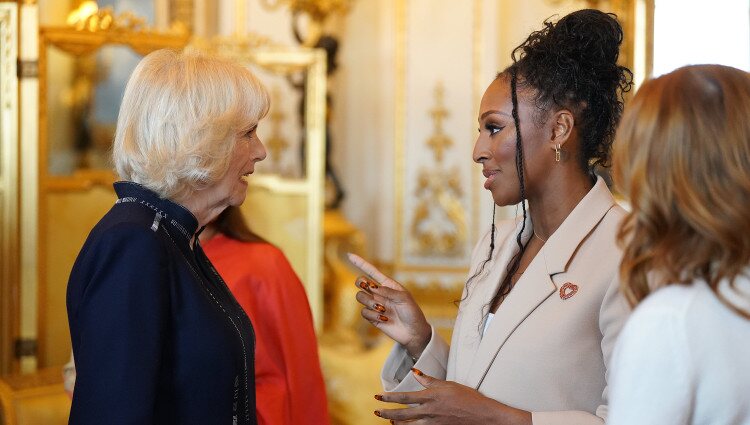 La Reina Camilla y Alexandra Burke hablando en la recepción a los ganadores del Queen's Commonwealth Essay Competition