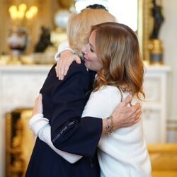 La Reina Camilla y Geri Halliwell dándose un abrazo en la recepción a los ganadores del Queen's Commonwealth Essay Competition