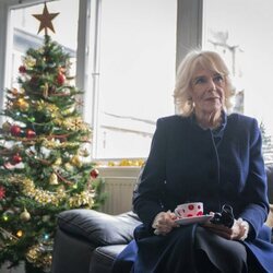 La Reina Camilla junto a un árbol de Navidad durante su visita a The Emmaus Community en Bobby Vincent House