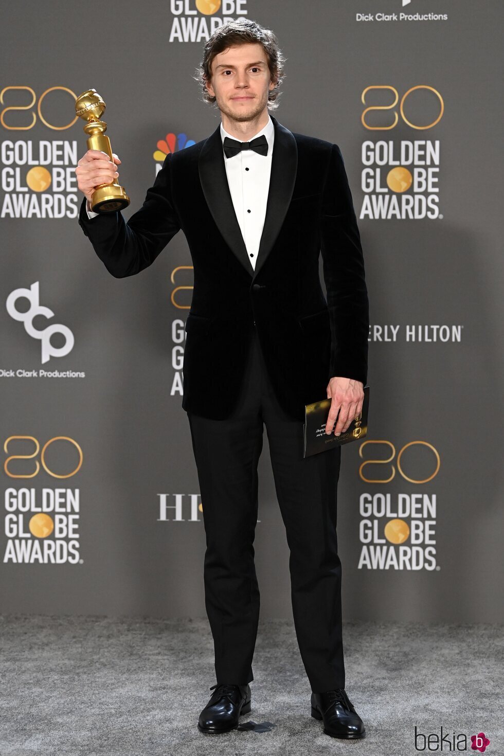 Evan Peters con su premio en los Globos de Oro 2023