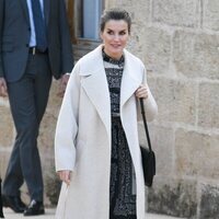 La Reina Letizia con abrigo largo y vestido de Mango en su visita a la Isla del Rey en Menorca