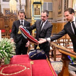 Pablo, Nicolás y Philippos de Grecia colocando las condecoraciones de Constantino de Grecia en el funeral de Constantino de Grecia