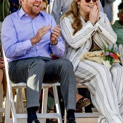 Guillermo Alejandro de Holanda y Amalia de Holanda riéndose en una ceremonia de bienvenida en Aruba