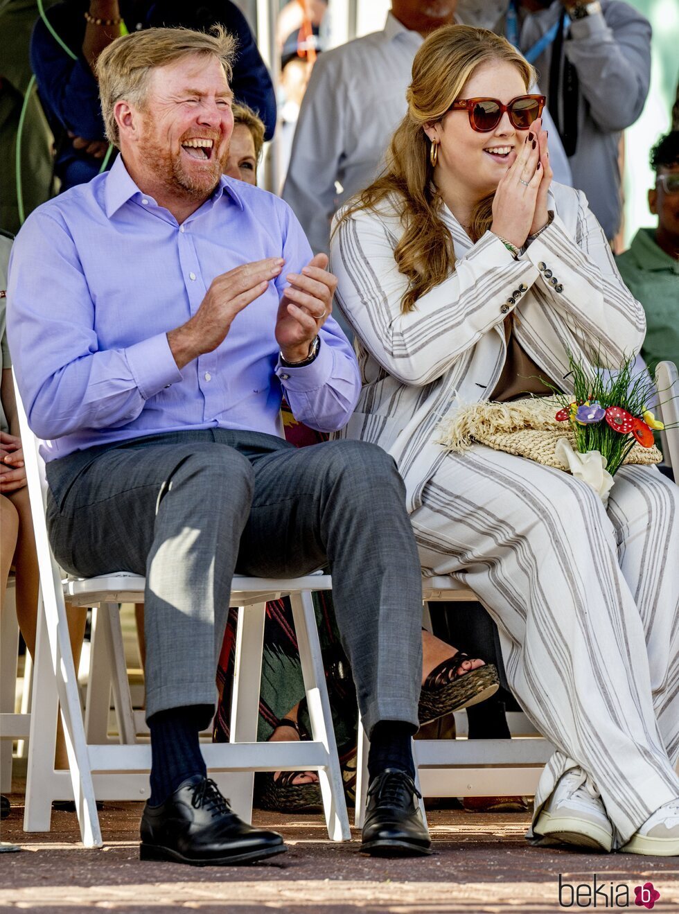 Guillermo Alejandro de Holanda y Amalia de Holanda riéndose en una ceremonia de bienvenida en Aruba