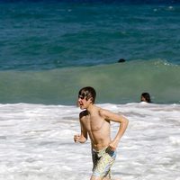 Justin Bieber corriendo en la playa con el torso desnudo