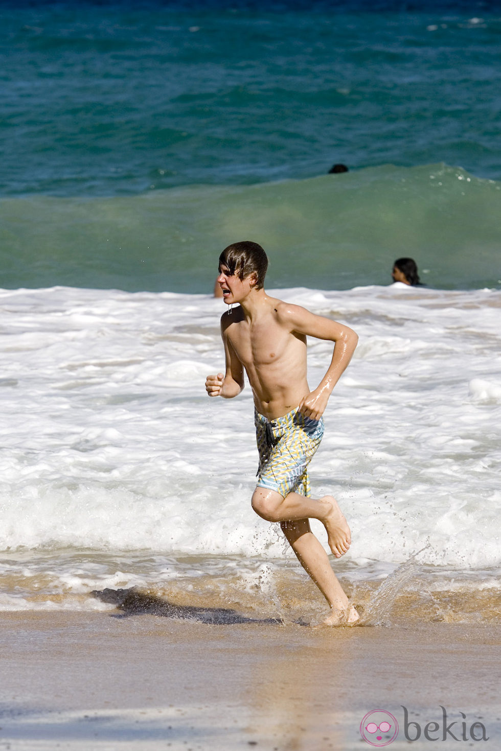 Justin Bieber corriendo en la playa con el torso desnudo