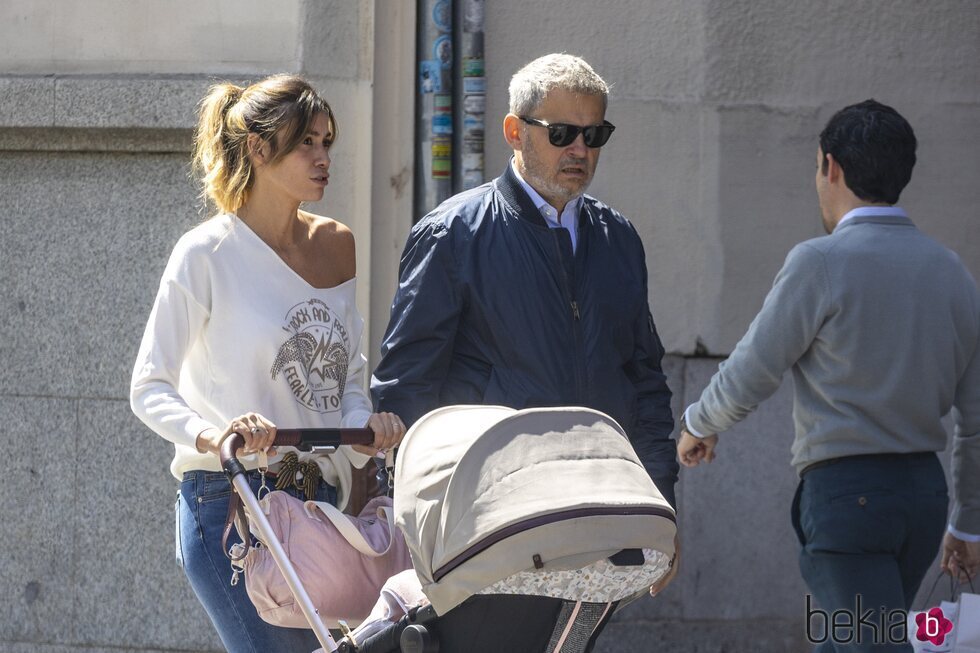 Miki Nadal y Helena Aldea paseando con su hija en el cochecito