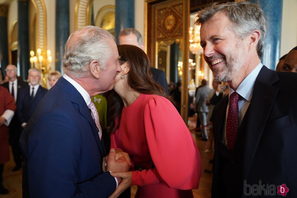 Carlos III besa a Mary de Dinamarca en presencia de Federico de Dinamarca en la recepción previa a la coronación de Carlos III