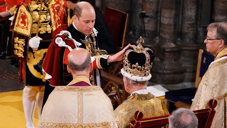 El Príncipe Guillermo posa su mano sobre la corona del Rey Carlos III