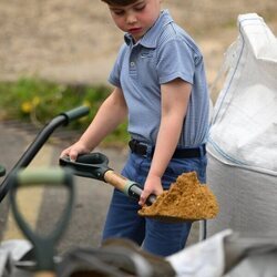 El Príncipe Louis cogiendo tierra con una pala en the Big Help Out por la Coronación