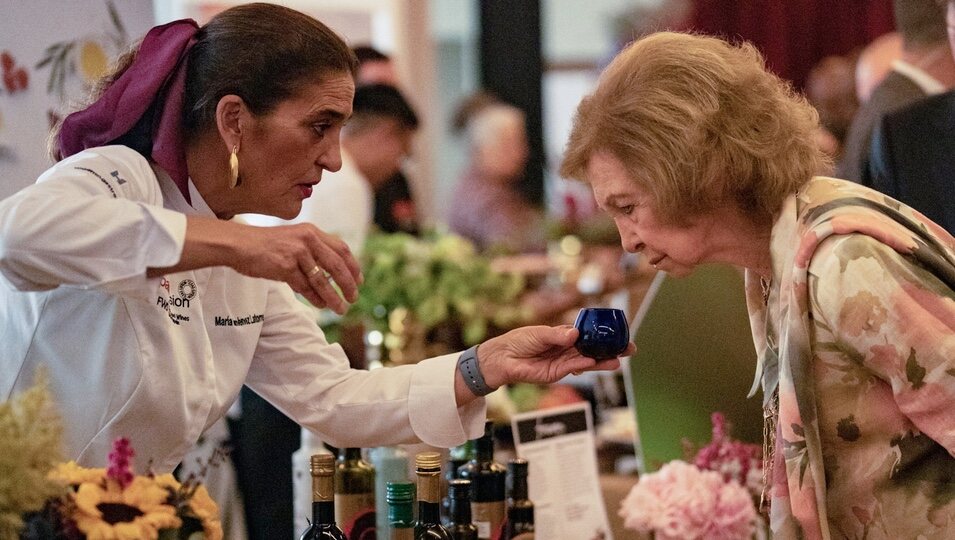 La Reina Sofía mirando un producto en la Spain Fusion Texas 2023 en Houston