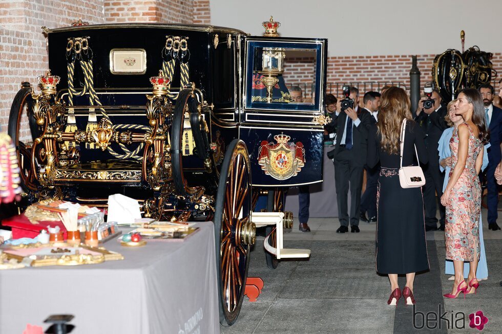 Rania de Jordania y la Reina Letizia ante un carruaje en las Escuelas Taller de Patrimonio Nacional