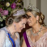 Matilde de Bélgica y Máxima de Holanda hablando en la cena por la Visita de Estado de los Reyes de Holanda a Bélgica