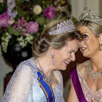 Matilde de Bélgica y Máxima de Holanda hablando en la cena por la Visita de Estado de los Reyes de Holanda a Bélgica