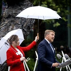 Guillermo Alejandro de Holanda pronuncia su discurso sobre la esclavitud mientras le tapan con un paraguas