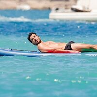 Sebastián Yatra tomando el sol sobre una tabla en Ibiza