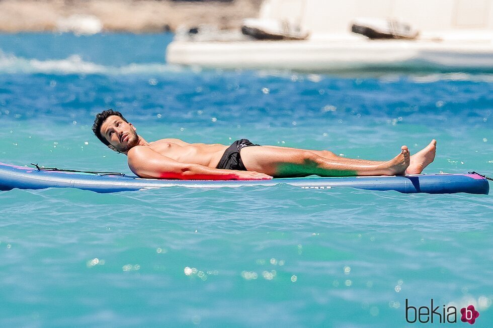 Sebastián Yatra tomando el sol sobre una tabla en Ibiza